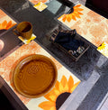 A picture of a dining table with yellow sunflower table mats